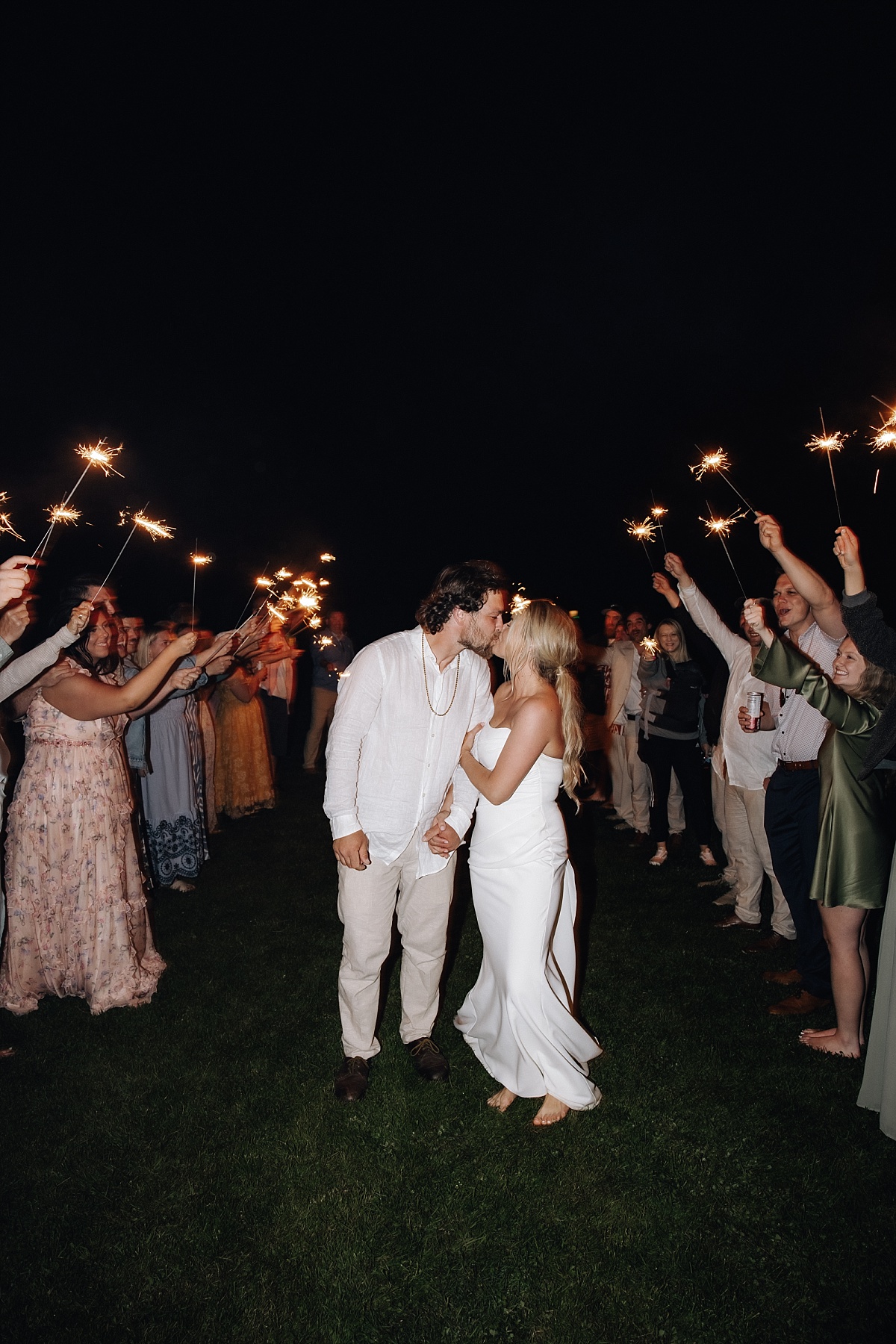 Joyful couple kissing at sparkler exit their Orcas Island wedding 