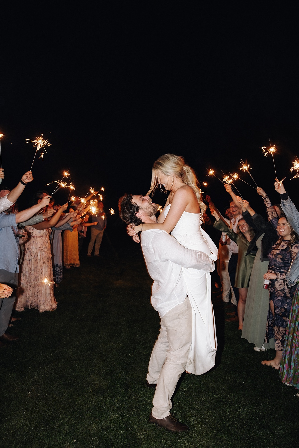 Joyful couple kissing at sparkler exit their Orcas Island wedding 