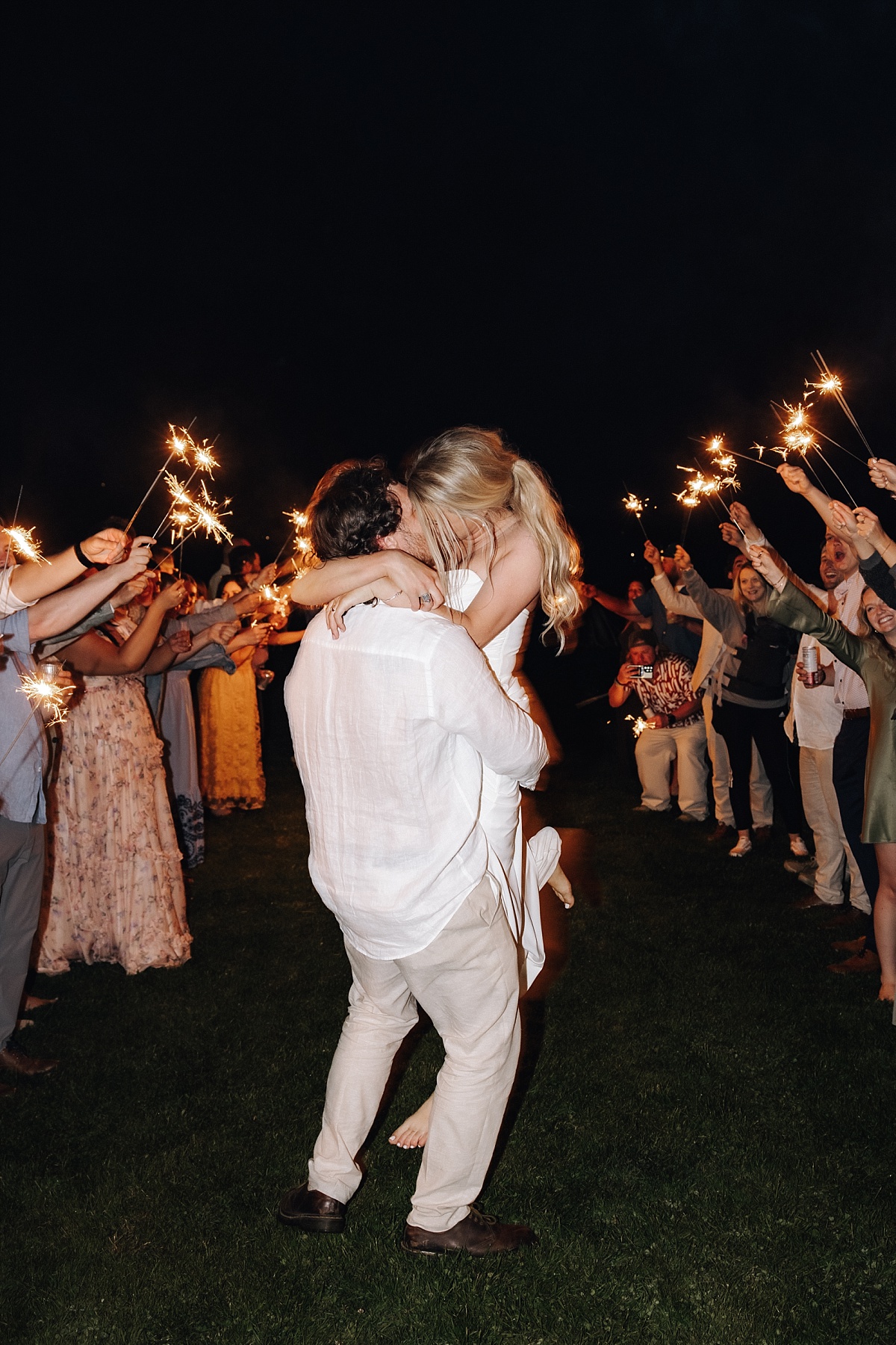 Joyful couple kissing at sparkler exit their Orcas Island wedding 